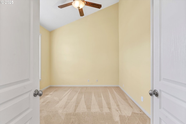 carpeted empty room featuring baseboards, a ceiling fan, and vaulted ceiling