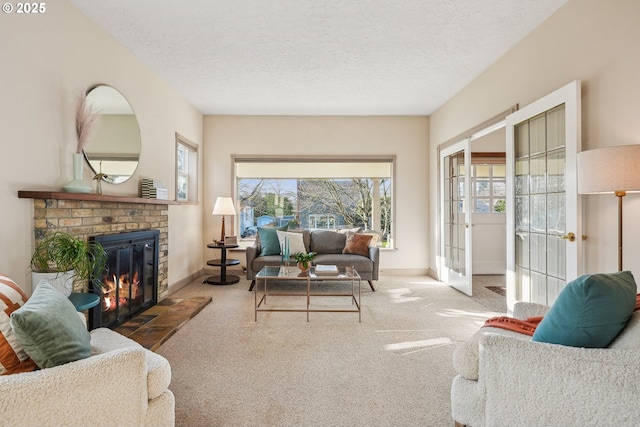 living room featuring a textured ceiling, french doors, a brick fireplace, and carpet