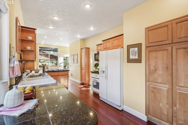 kitchen with white appliances, a textured ceiling, dark hardwood / wood-style floors, and sink