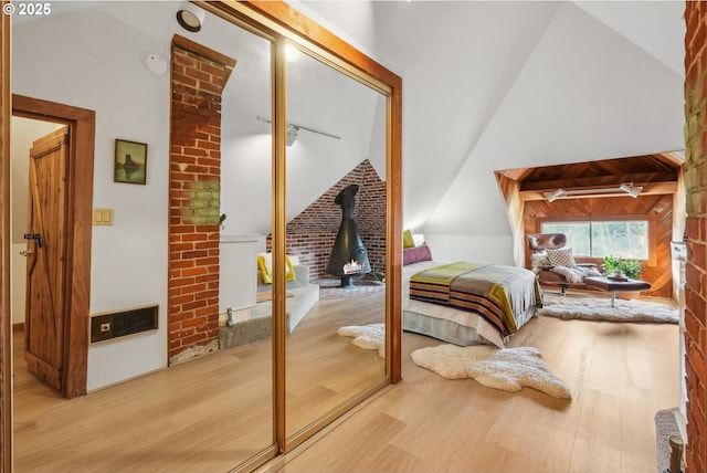 bedroom featuring a closet, hardwood / wood-style floors, and vaulted ceiling