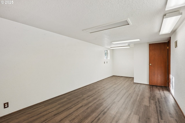 unfurnished room with a textured ceiling and hardwood / wood-style flooring