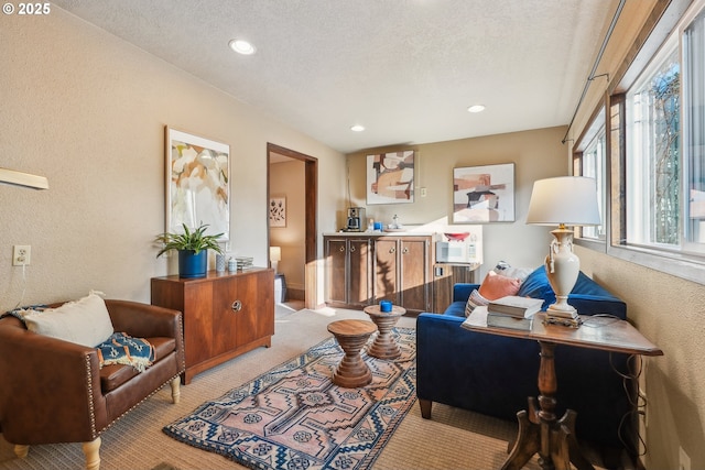 living room with a textured ceiling and light carpet