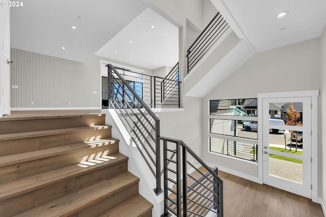 stairs featuring lofted ceiling and hardwood / wood-style floors