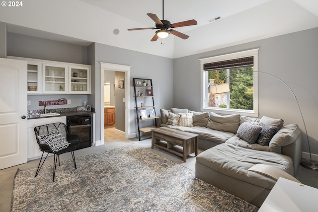 living room featuring ceiling fan, lofted ceiling, and sink