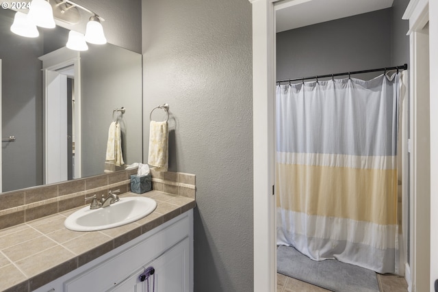 bathroom featuring tile patterned flooring, vanity, and tasteful backsplash