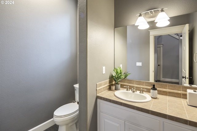 bathroom with tasteful backsplash, vanity, and toilet