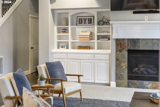 living area featuring a tile fireplace and hardwood / wood-style floors