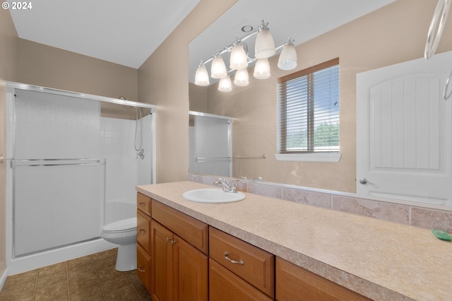 bathroom featuring toilet, tile patterned flooring, an enclosed shower, and vanity