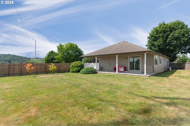 back of house featuring a patio, central AC, and a lawn