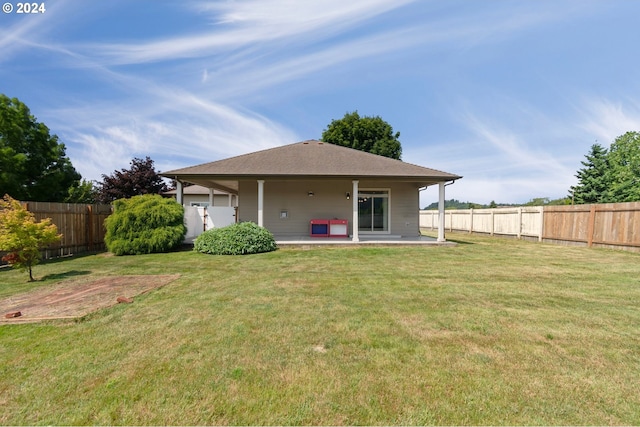 back of house featuring a lawn and a patio