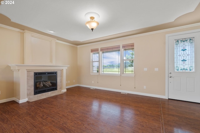 unfurnished living room featuring ornamental molding, dark hardwood / wood-style flooring, and a fireplace