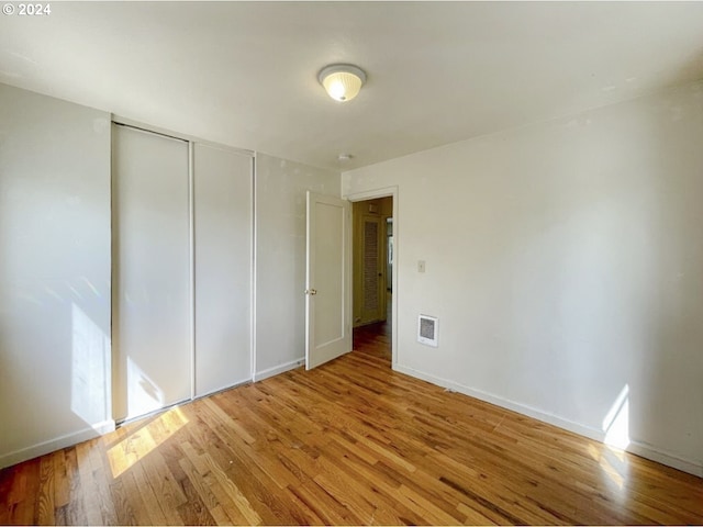 unfurnished bedroom with wood-type flooring and a closet