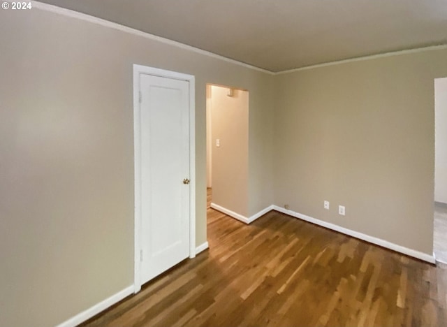 unfurnished room featuring dark hardwood / wood-style floors and crown molding