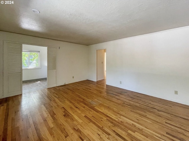 empty room featuring light hardwood / wood-style flooring and a textured ceiling