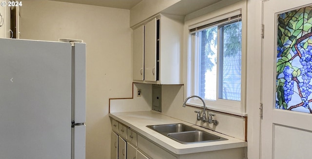 kitchen featuring white refrigerator, plenty of natural light, and sink