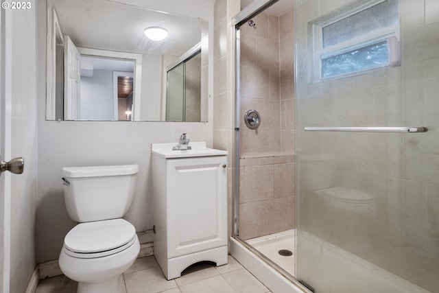 bathroom featuring tile patterned floors, vanity, toilet, and a shower with door