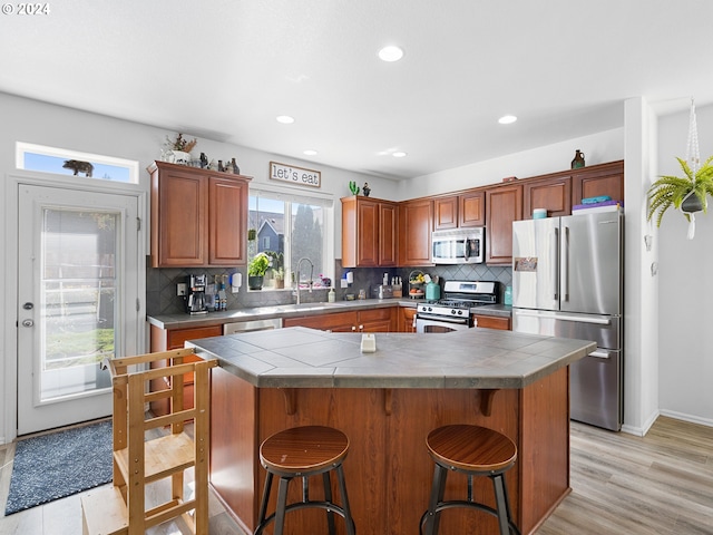 kitchen featuring stainless steel appliances, tile counters, tasteful backsplash, and sink