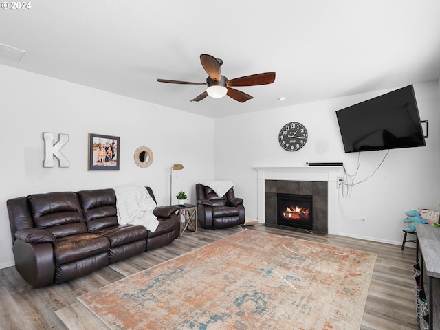 living room with a tile fireplace, ceiling fan, and hardwood / wood-style flooring