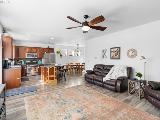 living room with light hardwood / wood-style floors and ceiling fan