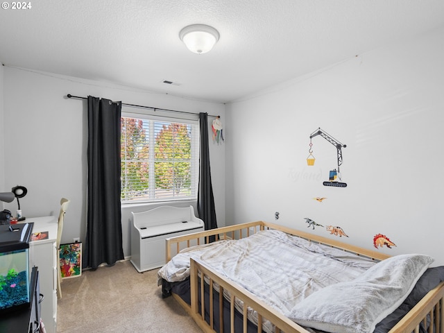 bedroom with a textured ceiling and light carpet