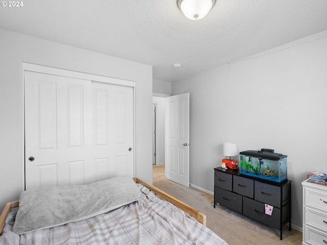 bedroom with light carpet, a closet, and a textured ceiling