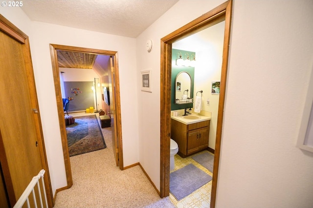 68191 E Twinberry Loop, Welches, OR 97067 - hallway featuring a sink, light colored carpet, baseboards, and a textured ceiling