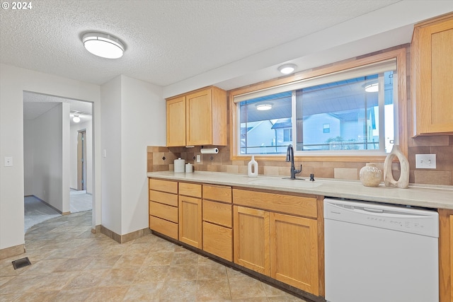 kitchen with backsplash, light tile patterned floors, white dishwasher, a textured ceiling, and sink