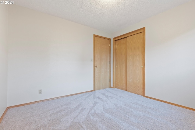 unfurnished bedroom featuring carpet, a closet, and a textured ceiling