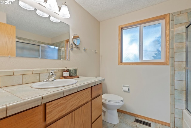 bathroom with vanity, a textured ceiling, an enclosed shower, toilet, and tile patterned floors