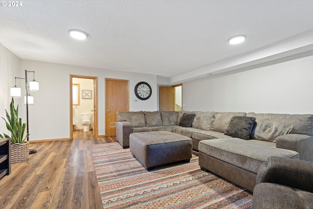 living room with a textured ceiling and hardwood / wood-style floors