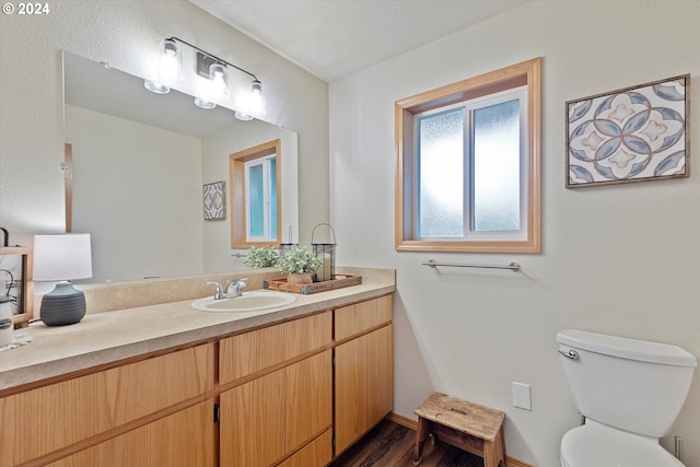 bathroom featuring wood-type flooring, vanity, and toilet