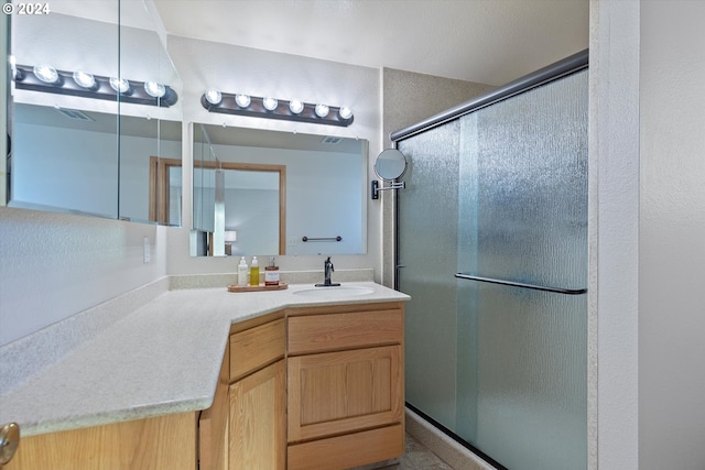 bathroom featuring vanity and a shower with shower door