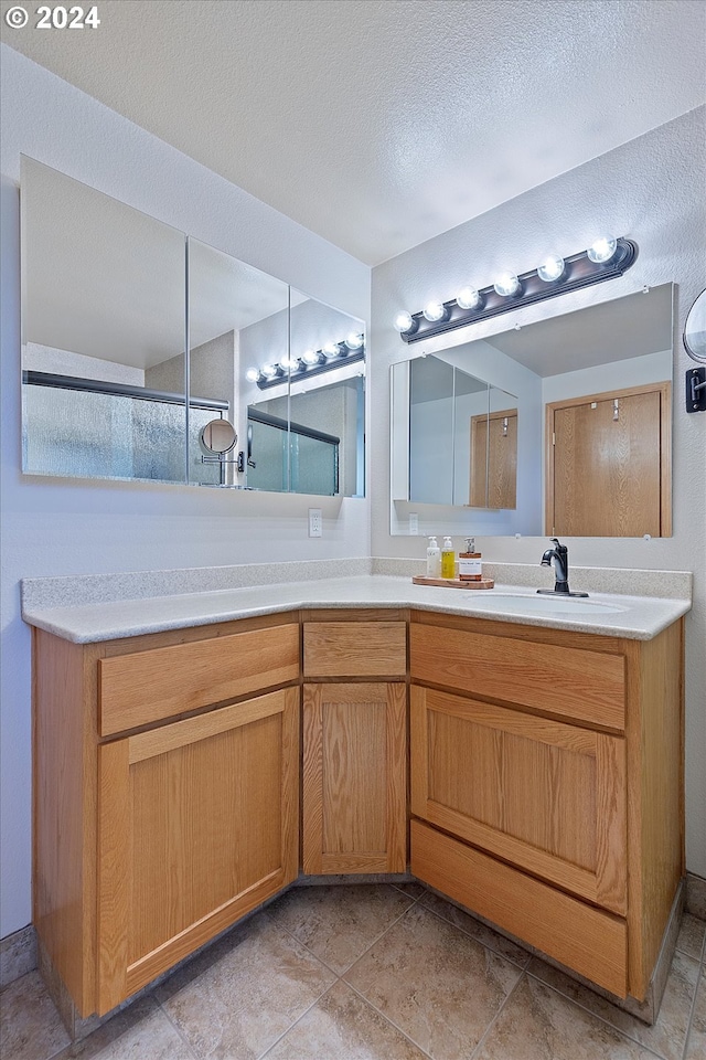 bathroom featuring tile patterned floors, a textured ceiling, and vanity