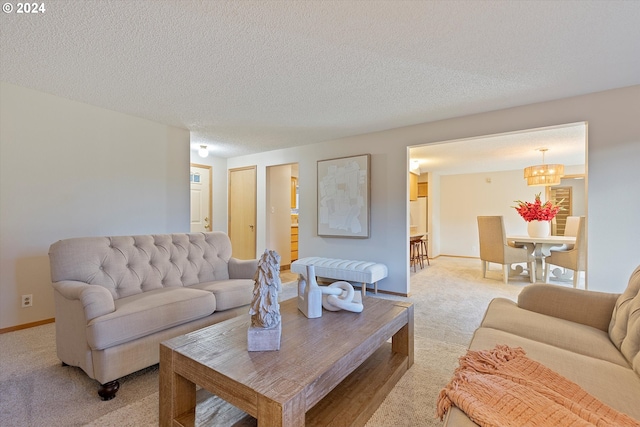 carpeted living room featuring an inviting chandelier and a textured ceiling