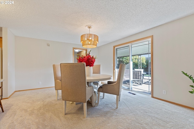 carpeted dining room with a textured ceiling