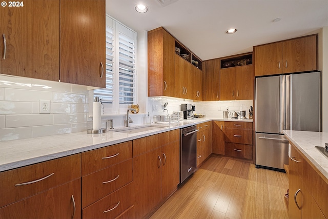 kitchen featuring backsplash, light hardwood / wood-style floors, sink, and stainless steel appliances