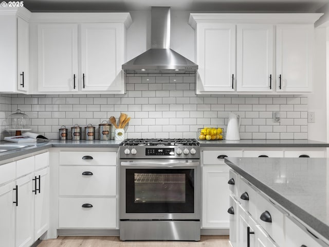 kitchen with white cabinetry, tasteful backsplash, stainless steel gas range, and wall chimney exhaust hood