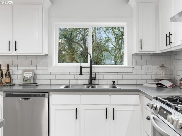 kitchen with sink, white cabinets, wall chimney exhaust hood, tasteful backsplash, and appliances with stainless steel finishes