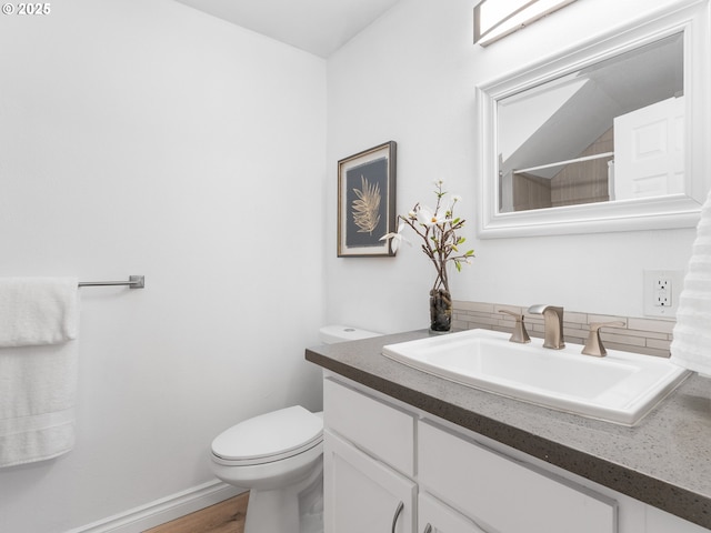 bathroom with walk in shower, hardwood / wood-style floors, vanity, and toilet