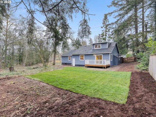 rear view of house with a wooden deck and a lawn