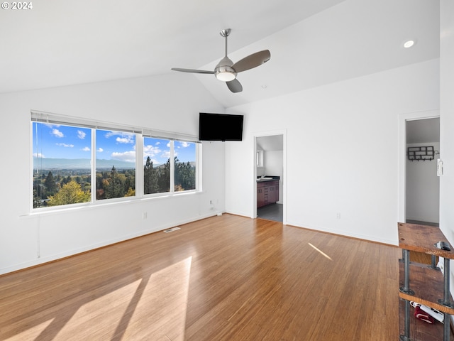 unfurnished living room with light hardwood / wood-style flooring, ceiling fan, and vaulted ceiling