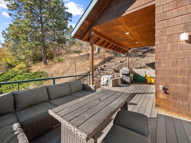 wooden deck featuring an outdoor living space and a grill