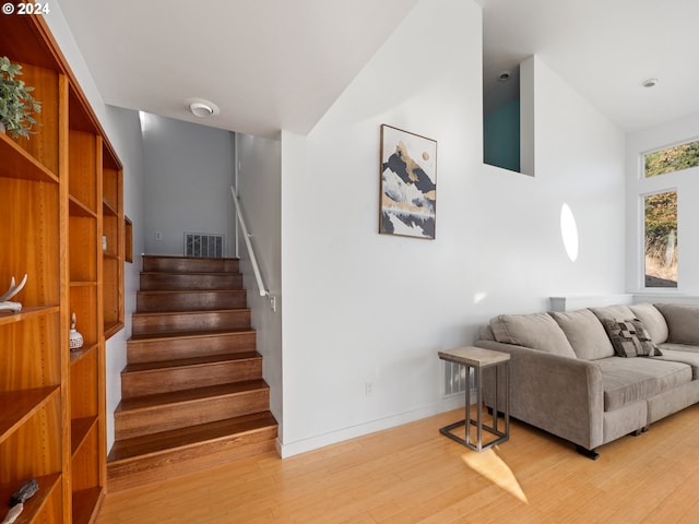 living room featuring vaulted ceiling and light hardwood / wood-style floors