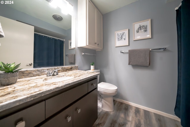 bathroom with vanity, toilet, and hardwood / wood-style floors