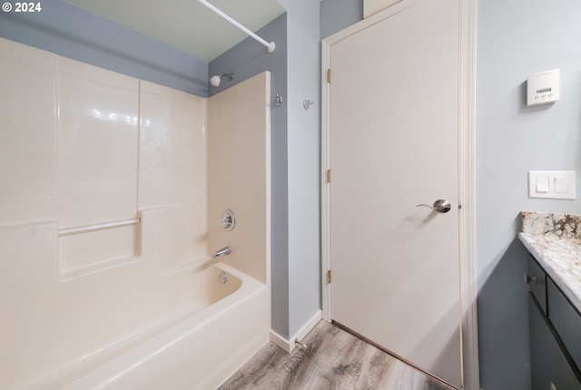 bathroom featuring vanity, wood-type flooring, and washtub / shower combination