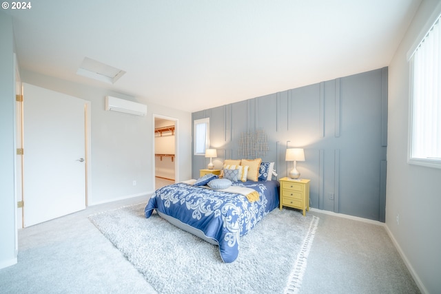 bedroom featuring a closet, carpet floors, a wall mounted air conditioner, and a walk in closet