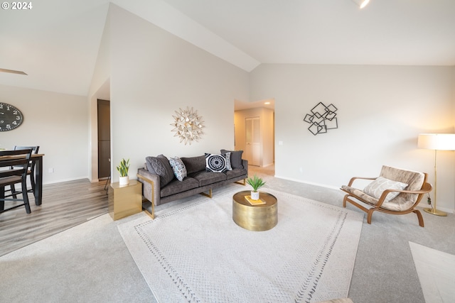 carpeted living room featuring high vaulted ceiling