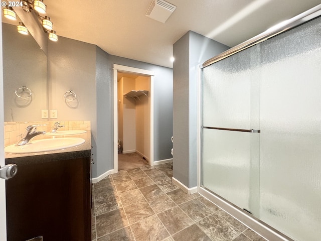 bathroom featuring an enclosed shower and vanity