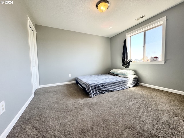 carpeted bedroom with a textured ceiling