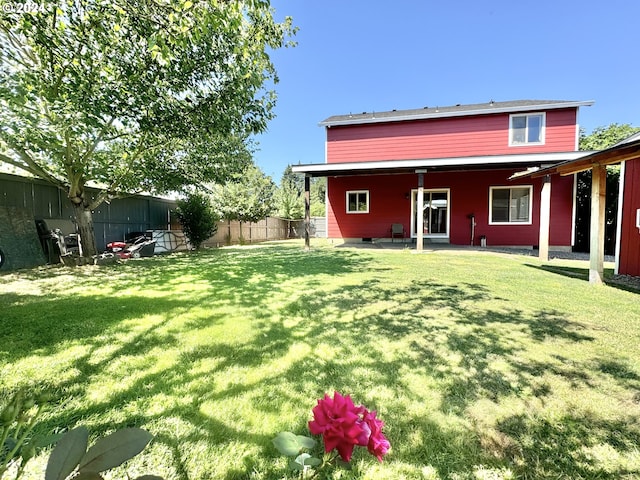 back of house featuring a patio and a yard